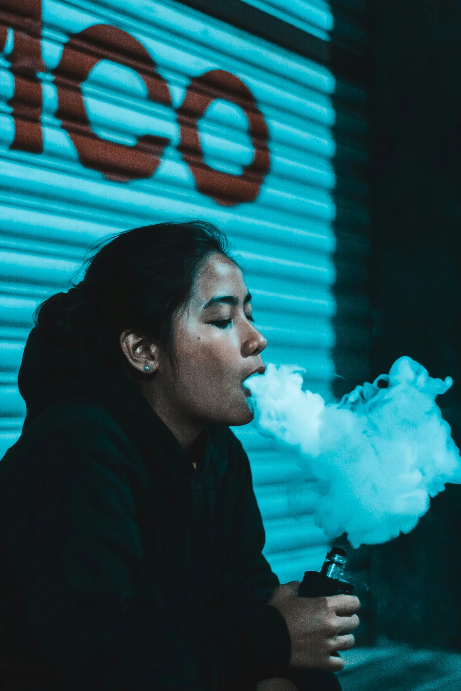 Une fille fume d'e liquide CBD avec un vaporisateur après le travail