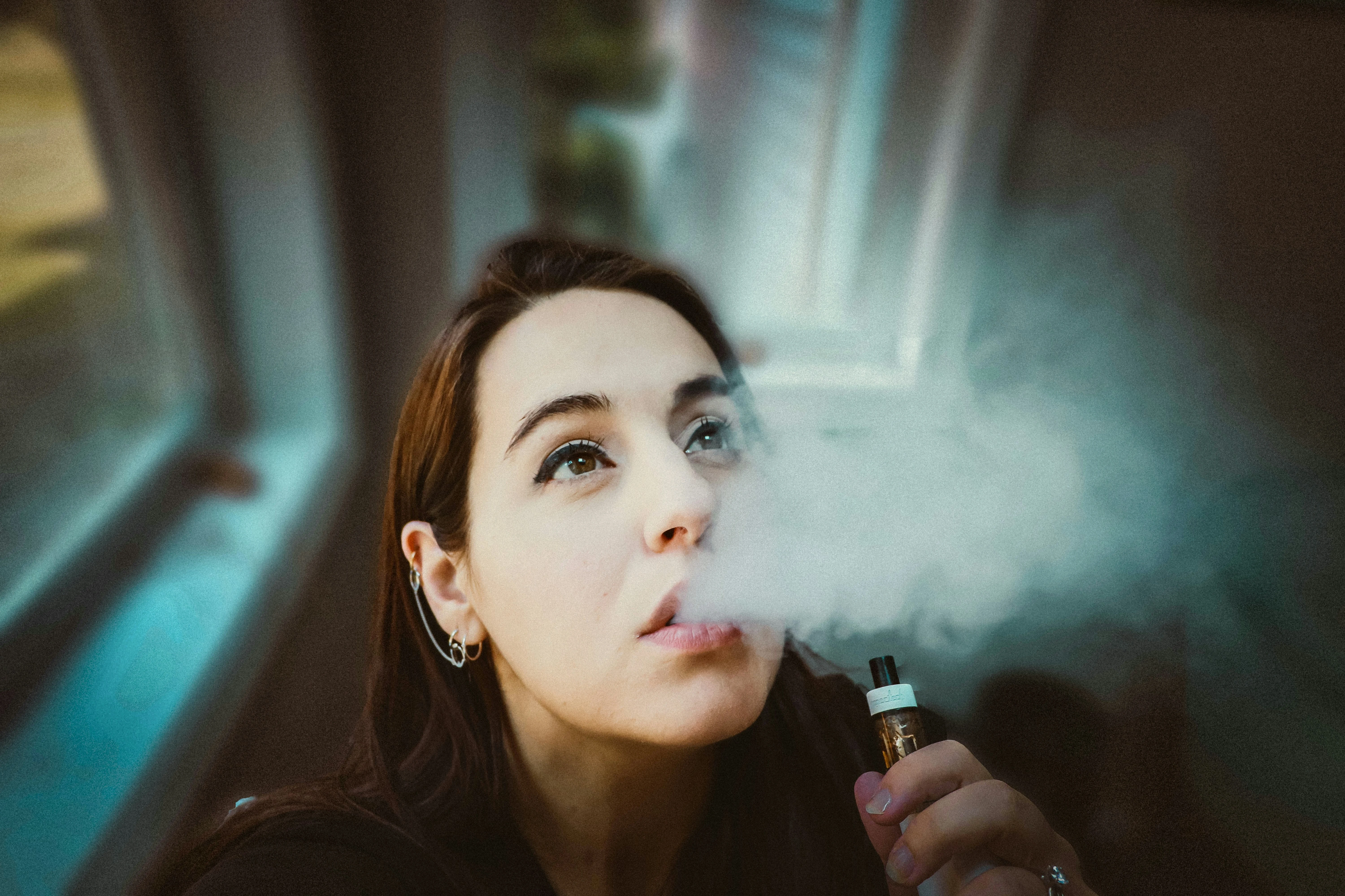 femme fumant du CBD  e-liquide avec un vaporisateur 