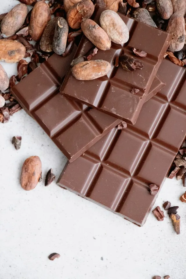 Des fèves de cacao et une table de chocolat, des aliments qui peuvent influencer l'effet du THC