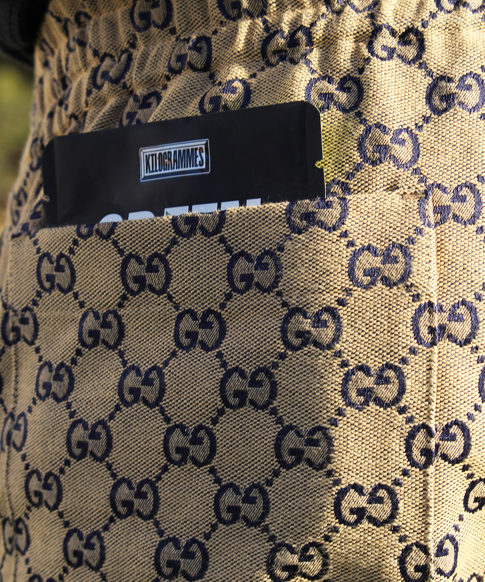 Un sweat shirt Gucci avec un sac de kilos dans la poche.