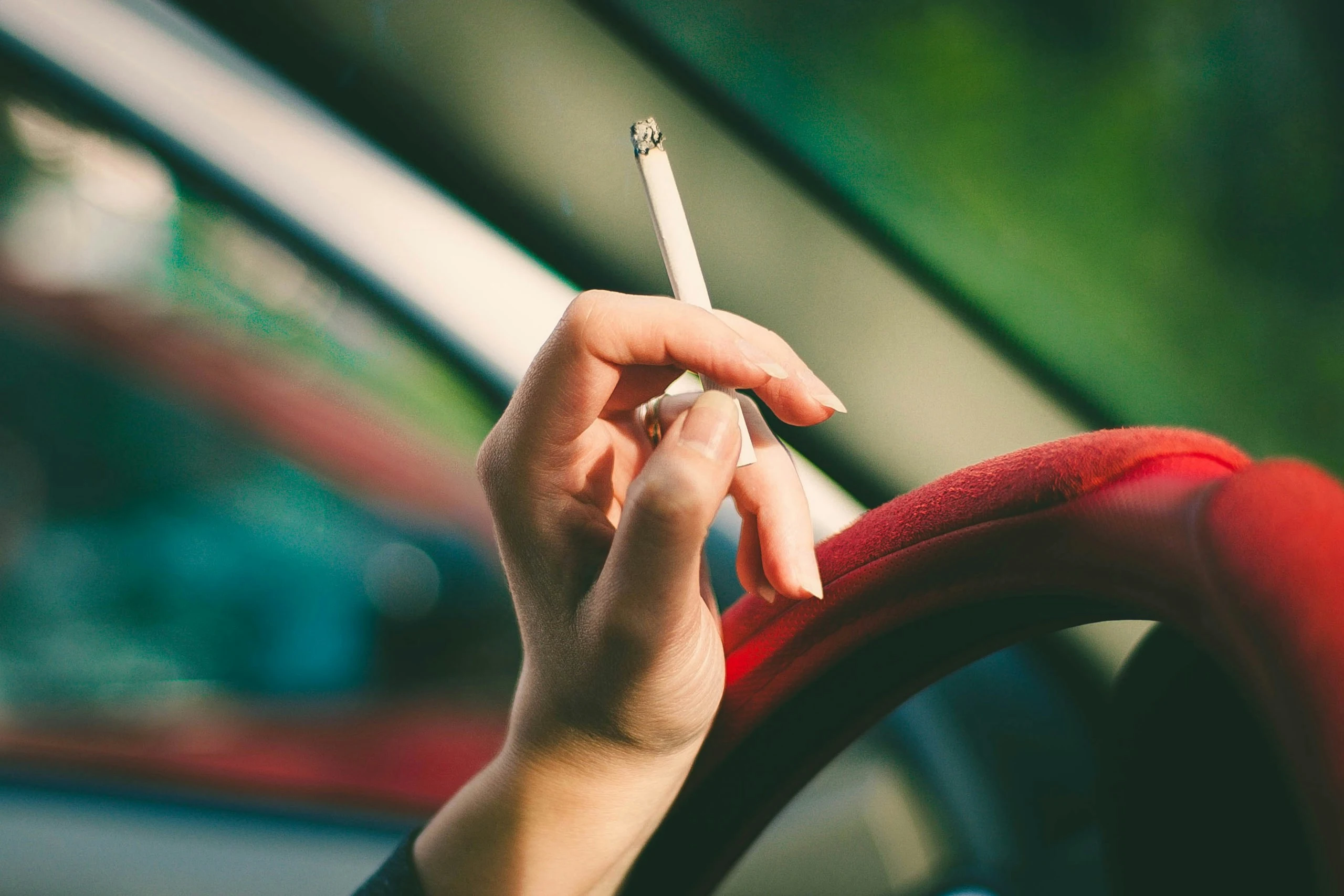 une personne fume du tabac en conduisant