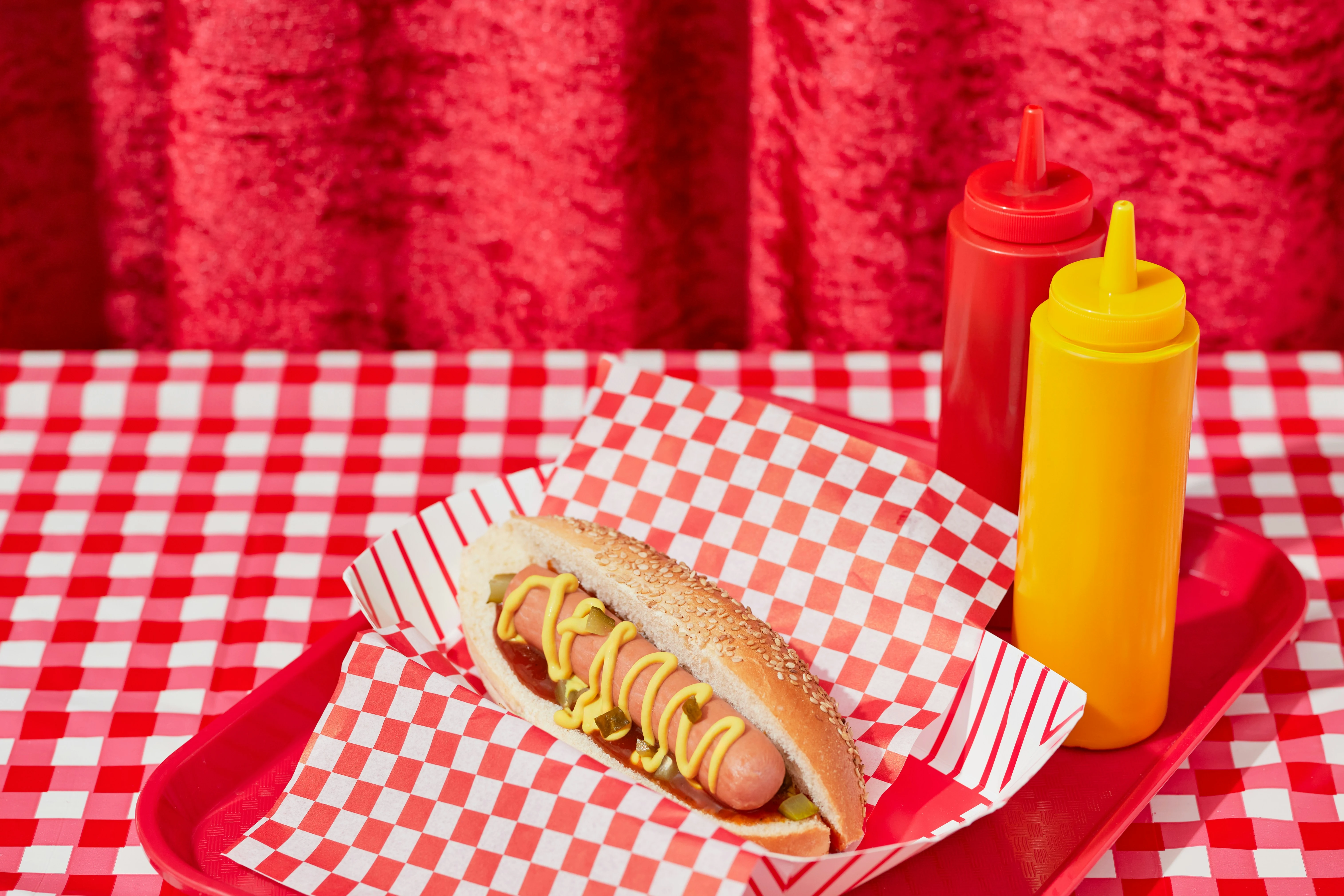 hot-dogs avec mayonnaise au cannabis CBD sur une table rouge, prêts à être dégustés